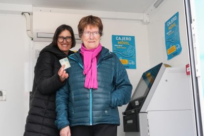 La alcaldesa de Cogeces de Íscar (Valladolid), Arantxa Herrero, enseña la primera retirada de efectivo del cajero efectivo del municipio junto a una vecina. -J.M. LOSTAU