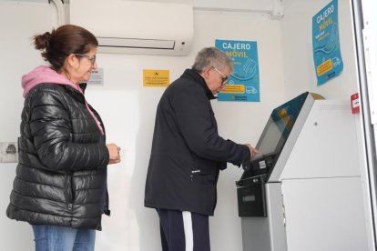 Mari Carmen y su marido usan el cajero móvil en Cogeces de Íscar (Valladolid). -J.M. LOSTAU