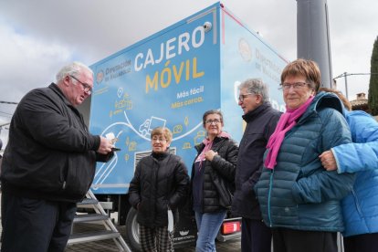 Vecinos de Cogeces de Íscar (Valladolid) aguardan su turno para usar por primera vez el cajero móvil. -J.M. LOSTAU