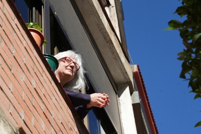 Una vecina toma el sol asomada a la ventana en la calle Covadonga de Valladolid en la actualidad. - J.M. LOSTAU