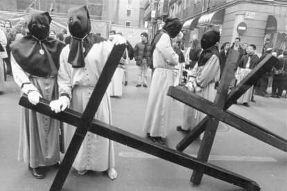 Penitentes sujetando sus cruces antes de comenzar la procesión de la Semana Santa de 1997 en la calle de las Angustias