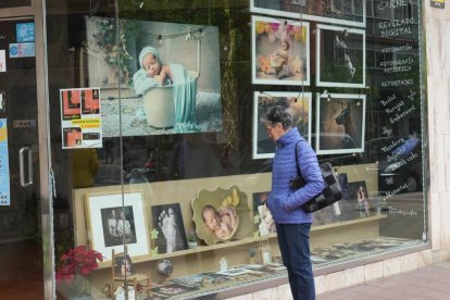 Persona contemplando el escaparate del estudio de fotografía 'ÑFotógrafos' en la calle de los Alamillos en Valladolid