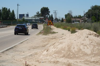 Señal de obra y montículo de arena.