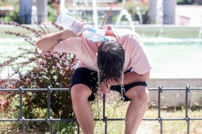 Una persona se refresca con agua en una imagen de archivo
