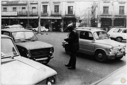 Plano general de un policía multando a un vehículo mal estacionado en Fuente Dorada en1970
