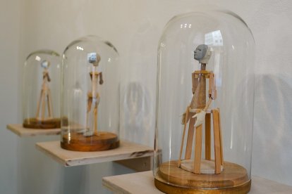 Figuras a modo de vírgenes de vestir, en una campana de cristal
