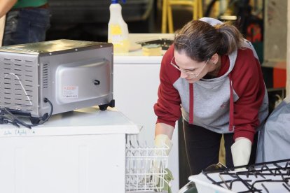 Sofía limpia uno de los electrodomésticos para llevarlos a Valencia y donarlos a gente