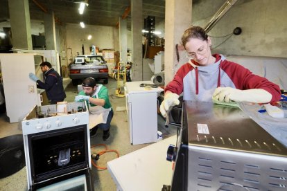 Jacob, Sofía y Javier, voluntarios que están limpiando electrodomésticos para llevarlos a Valencia y donarlos a gente