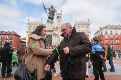 Voluntarios colocándose el brazalete verde contra el cáncer.