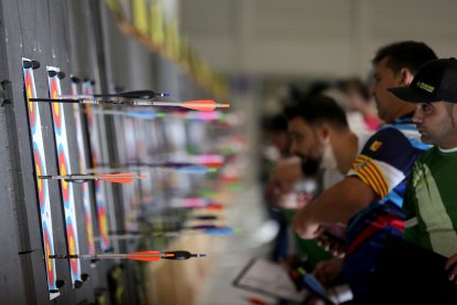 Varios tiradores miran sus puntuaciones en las dianas.