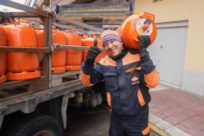 Un trabajador descarga una bombona de butano en la calle Gallo.