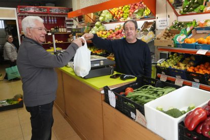 Miguel Rodríguez, propietario de la frutería Rosi, atiende a Onésimo Lobato, un cliente de toda la vida.