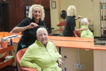 Arancha López, dueña de la peluquería Arancha, acaba de peinar a su clienta Rosario Maeso.