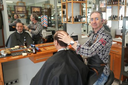 José Manuel Rodríguez, propietario de la peluquería Urbano, corta el pelo a Luis Melero, un cantaor flamenco de Valladolid