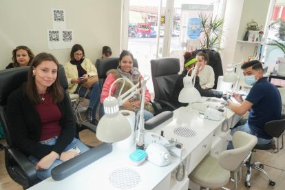 Clientas del salón de uñas Vietnamita esperan su turno.