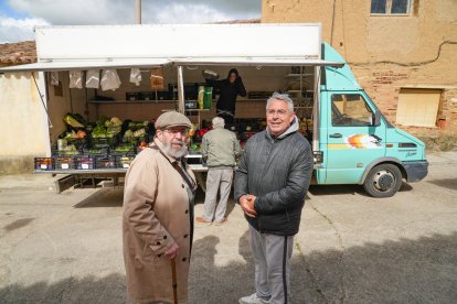 Dos vecinos esperan su turno en la frutería.