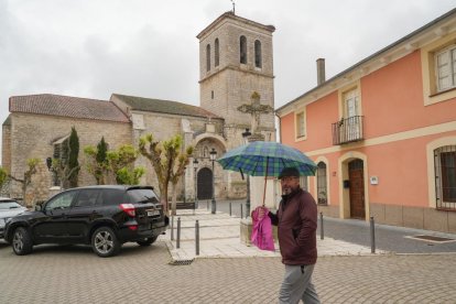 Un vecino pasa delante de la iglesia de San Juan Evangelista.