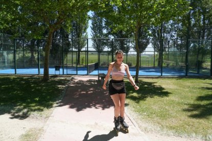 Silvia Asensio patina en el parque delante de la pista de padel.