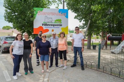 Eva, Silvia, Sergio, Espe, Tomás, Juani y el Alclalde Diego posan delante de el cartel de Bienvenidos, a la entrada del pueblo.