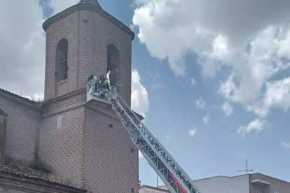Bomberos saneando la fachada de la Iglesia de San Pedro en Olmedo, Valladolid.