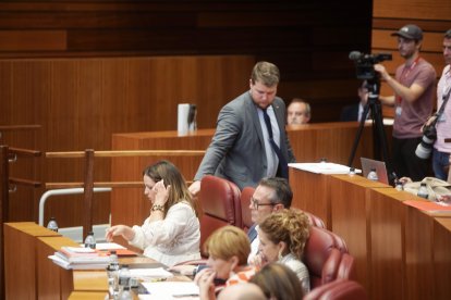 El procurador de VOX Suárez Arca pasa delante de los escaños del PSOE, justo detrás de Patricia Gómez Urbán.
