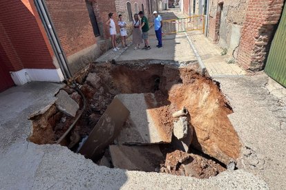Vecinos de Rodilana observan en enorme socavón en la calle Murga del barrio periférico de Medina del Campo.