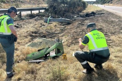 Dos agentes de la Guardia Civil inspeccionan los restos del Lamborghini Huracán