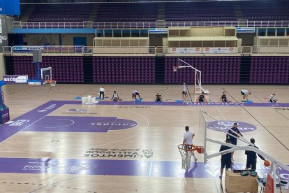 La plantilla del UEMC Baloncesto Valladolid entrenando en Pisuerga con los cubos por las goteras.