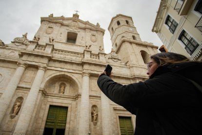 Una mujer toma una foto a la Catedral.