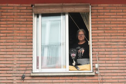 Una mujer asoma con su perro por una de las ventanas de la calle de San Lázaro de Valladolid.