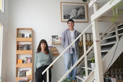 Arancha Mateo con Aster Frechilla, equipo de la librería Caliza posan entre los libros y una foto de Ricardo Suárez