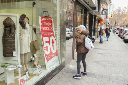 Una mujer mira uno de los escaparates de la calle Tudela.