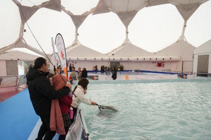 Unos niños aprenden a pescar en la Cúpula del Milenio.