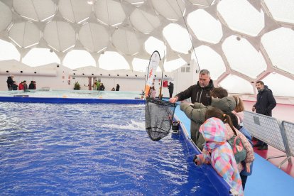 Unos niños aprenden a pescar en la Cúpula del Milenio.