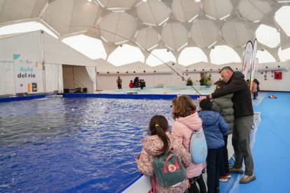 Unos niños aprenden a pescar en la Cúpula del Milenio.