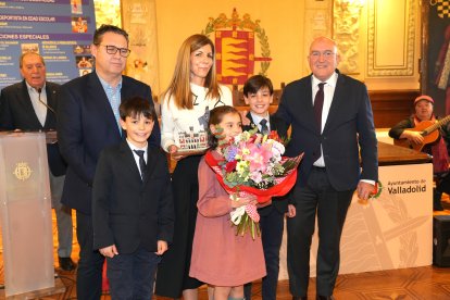 Jesús Julio Carnero, junto a Guillermo Velasco, entregan el galardón póstumo y un ramo de flores a la familia de Gonzalo Cebrián.