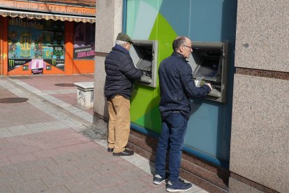 Dos hombres utilizan uno de los cajeros de la calle Cardenal Cisneros.