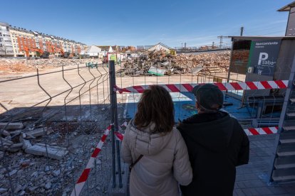 Dos personas observan los trabajos de demolición de la estación de tren de Valladolid.