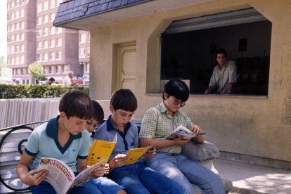 Niños leyendo junto a la caseta de la biblioteca municipal de la plaza Poniente en los años 80