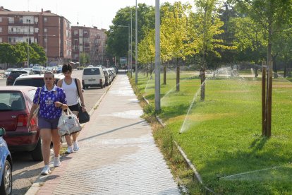 Varias personas pasan por al lado del parque de La Paz.