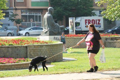 Varias personas pasean a su mascotas por el parque de La Paz.