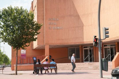 Varias personas sentadas delante de la fachada de la Escuela Oficial de Idiomas de Valladolid.