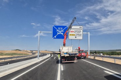Momento en que los operarios cambian los carteles informativos de la A-11 para colocarlos como deberían estar.