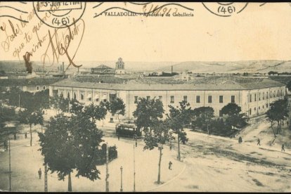 Tarjeta postal sobre el año 1910 con una vista panorámica del antiguo edificio de la Academia de Caballería y, al fondo, se ve la desaparecida iglesia de San Ildefonso.