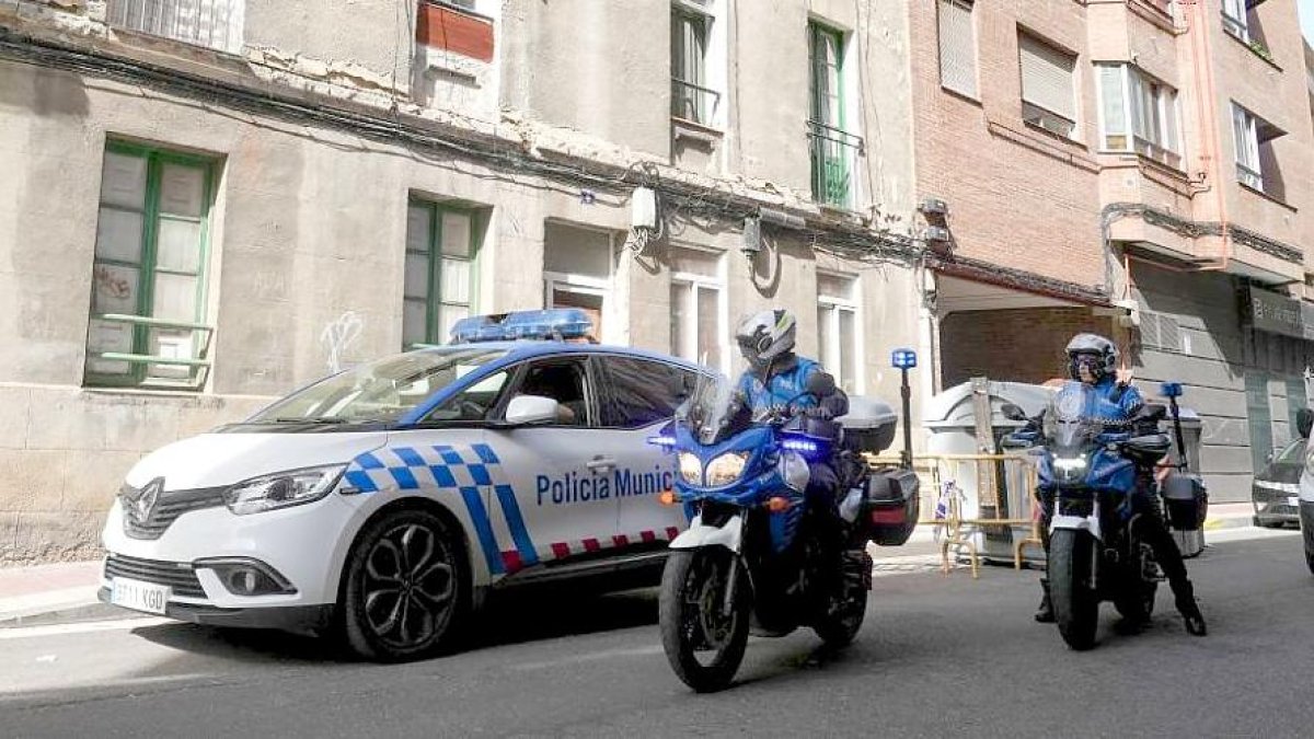 Patrulla de la Policía Municipal en la entrada del edificio okupado en el momento en que llegan dos efectivos de la Policía Nacional. J. M. LOSTAU