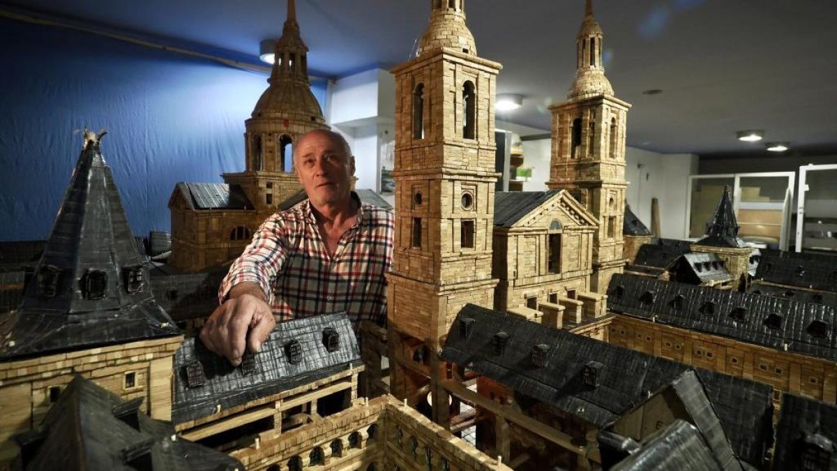 Ángel Rodríguez, en su estudio, posa junto a su maqueta de El Escorial