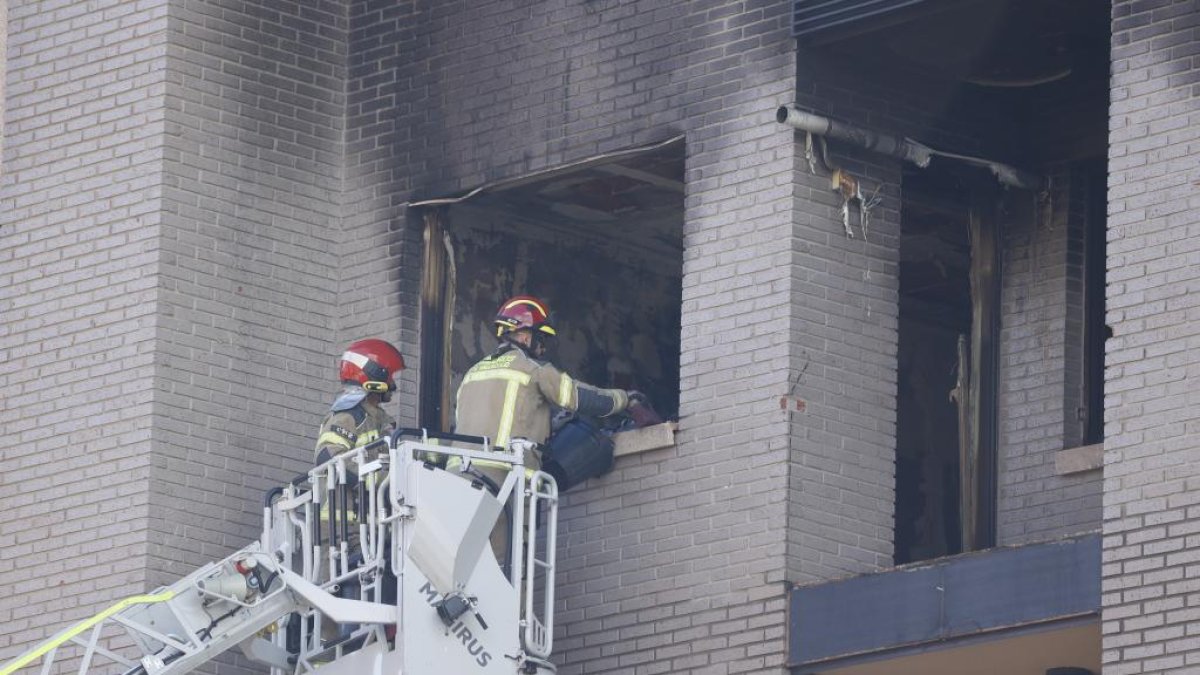 Detalle de los daños en una ventana mientras acceden los bomberos.- PHOTOGENIC