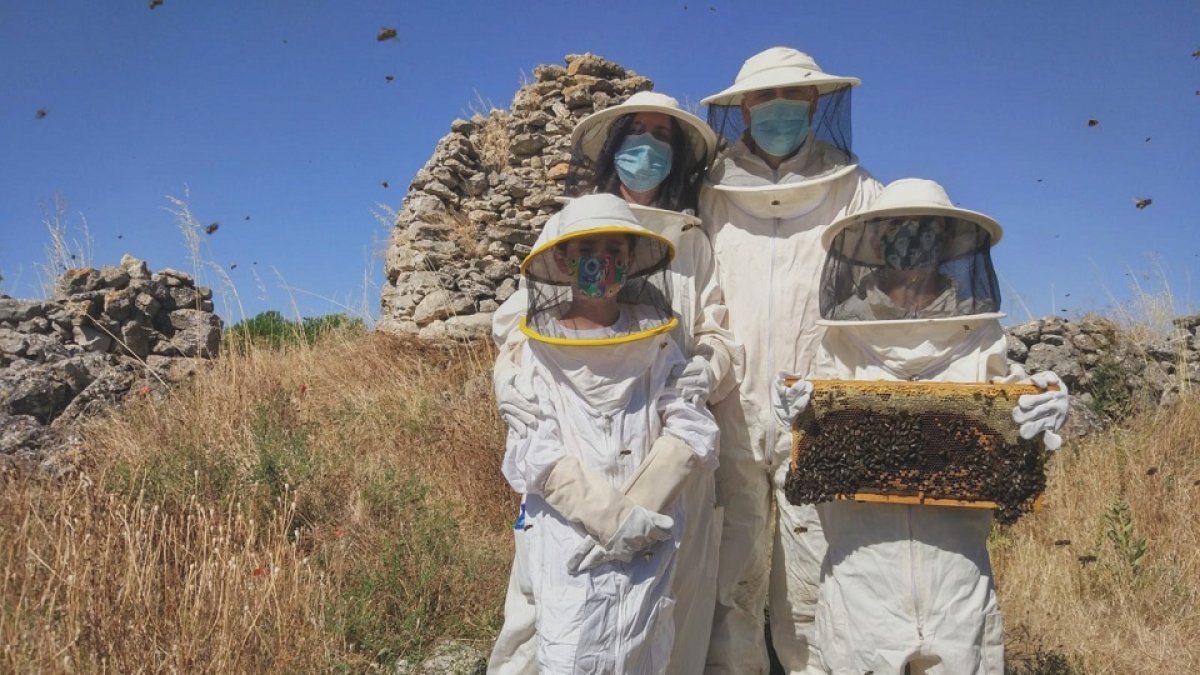 Una familia posa con un panal durante su visita al Aula de las abejas del Cerrato. E.M.