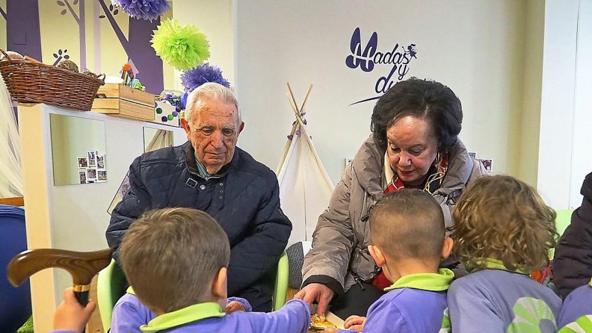 Varios niños y ‘abuelos’ comparten un puzle durante una jornada del programa ‘Contigo, conmigo’.-MIGUEL ÁNGEL SANTOS