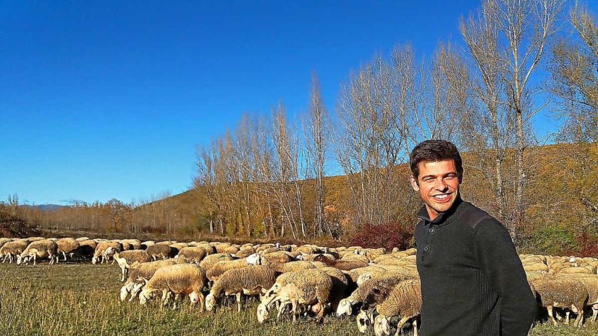 Javier Manzano Figal, ganadero leonés de 29 años, con sus ovejas en el Valle del Curueño.-E.M.